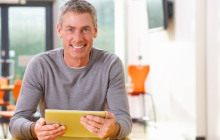 Mature Student Studying In Classroom With Digital Tablet